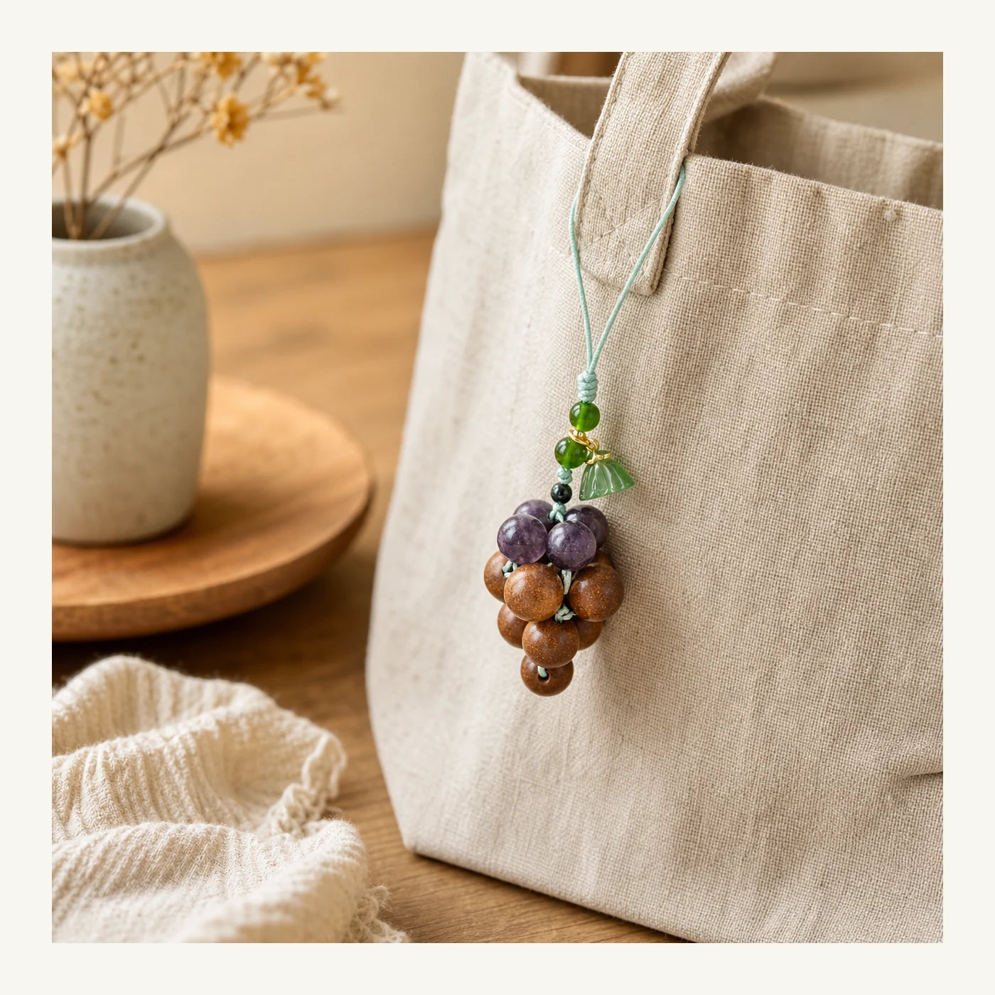 Lavender Osmanthus Grape Incense Bag Charm styled on a linen bag