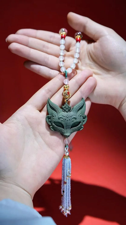Lavender scent fox pendant necklace held in hand with beaded tassel